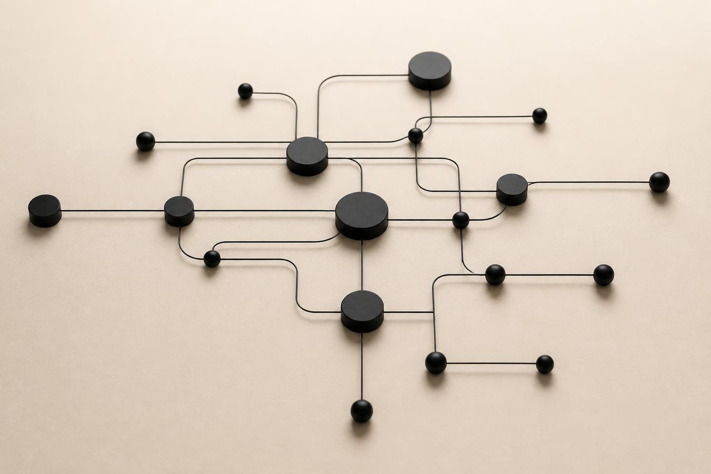 Sculpture abstraite de nœuds noirs reliés par des fils fins formant un diagramme de flux sur fond crème